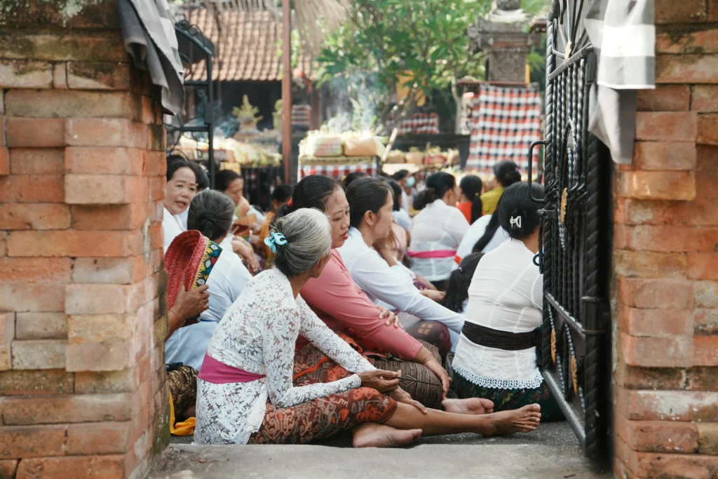 Balinese people gathering in a traditional setting, embracing the wisdom of rest and reflection.
